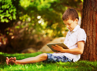 Boy on grass with tablet computer