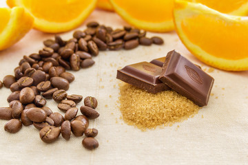 Pieces of chocolate on brown sugar, surrounded by orange slices