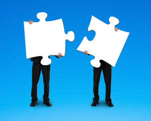Two businessmen assembling puzzles