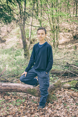 Good looking boy standing in a forest