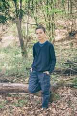 Good looking boy standing in a forest