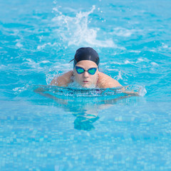 Fototapeta na wymiar Young girl swimming butterfly stroke style