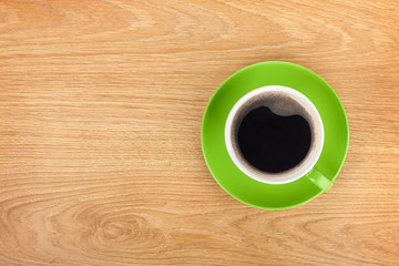Green coffee cup on wooden table