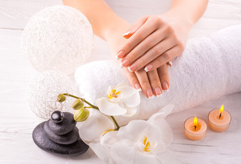 Beautiful hands with manicure and wnite orchid flower