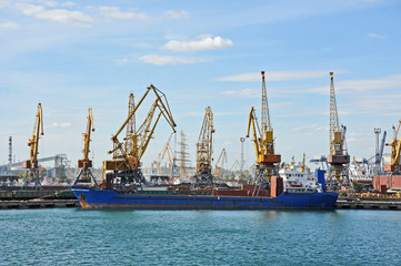 Obraz premium Bulk cargo ship under port crane bridge, Odessa, Ukraine