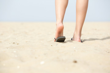 Low angle woman walking away at beach