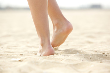 Woman walking barefoot on sand