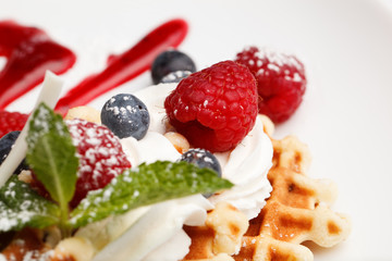 Waffle and cream topped with fresh berries