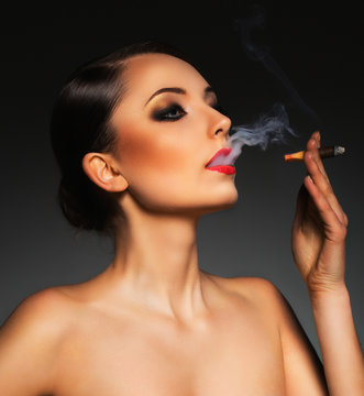 Portrait of a beautiful woman with cigar and with a glamorous re