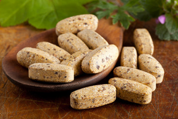 Herbal vitamin and supplement pills on spoon
