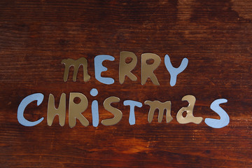 Merry Christmas lettering on wooden table close-up