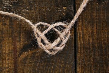 Heart shape from rope, on wooden background