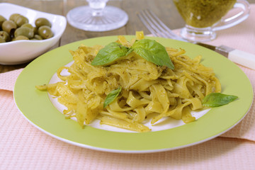 Delicious pasta with pesto on plate on table close-up