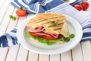 Tasty sandwich with ham on wooden table