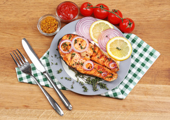 Tasty grilled salmon with vegetables, on wooden table