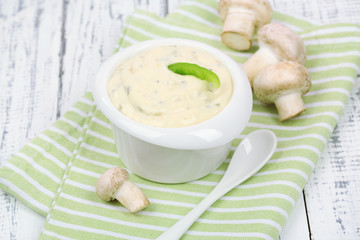Delicate mushroom sauce in bowl on wooden table close-up