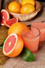 Ripe grapefruit with juice on table close-up