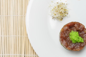 Salmon with tartar sauce and lime on simple white plate