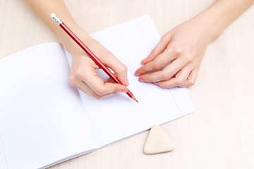 Human hands with pencil writing