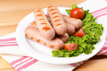 Grilled sausage on plate on table close-up