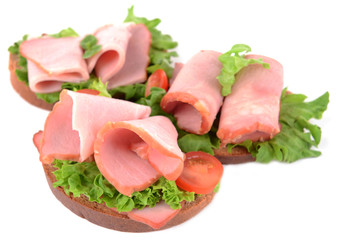 Delicious sandwiches with lettuce and ham isolated on white