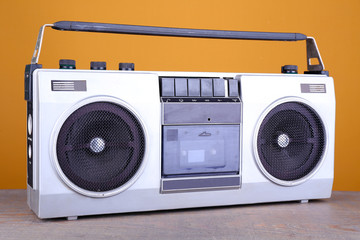 Retro cassette stereo recorder on table on yellow background