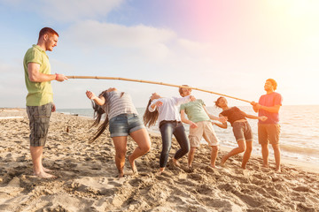 Friends Dancing Limbo at Beach - obrazy, fototapety, plakaty