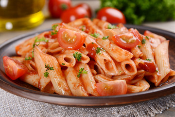 Pasta with tomato sauce on plate on table close-up