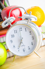 Back to school , note book , clock , pencil , apple on wood tabl
