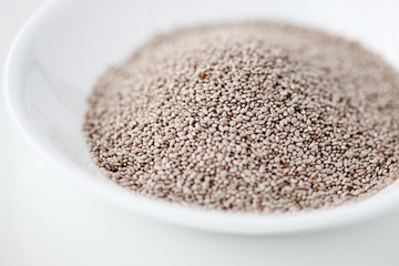 White chia seeds in a bowl against white background