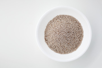 White chia seeds in a bowl against white background