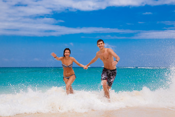 happy couple running on the beach