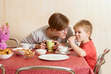 The small boy and his mother eat pancake