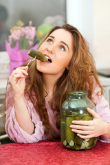 The young girl with glass can of pickled cucumbers - 63797742