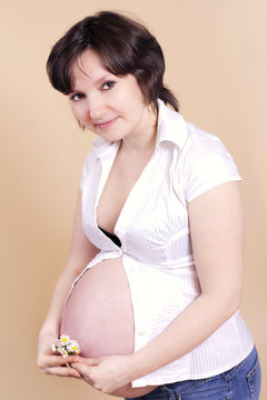 Beautiful pregnant woman with daisy