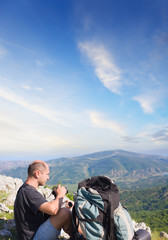 Fototapeta premium tourist on top of a mountain takes a snapshot of the nature