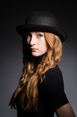 Fototapeta na wymiar Redhead girl in hat against grey background