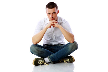 Confident man sitting at the floor over white background