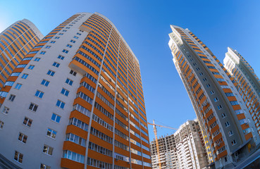 Fototapeta na wymiar Wysokie budynki mieszkalne na tle niebieskiego nieba