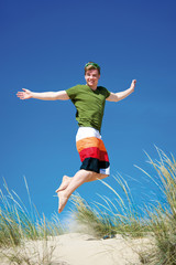 Teenager springt auf Sanddüne