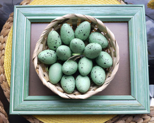 green Easter eggs in a straw basket in old mint a frame