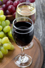 glass of red and white wine, grapes on a wooden board