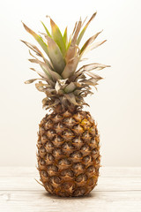 Single pineapple on wooden board