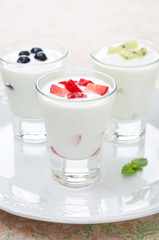 three yogurt with fruit in a glass beaker