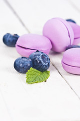 Obraz na płótnie Canvas macaroons fresh blueberries on white wooden background