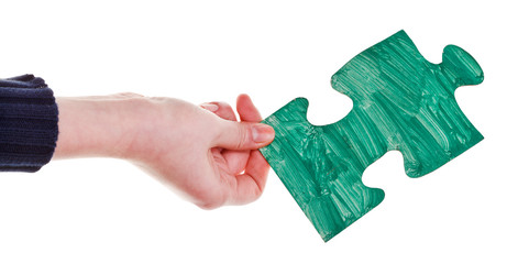 female hand with painted green puzzle piece