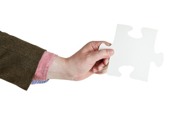 male hand holding big white paper puzzle piece