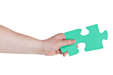 male hand holding big green paper puzzle piece