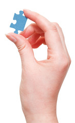 female arm holding jigsaw puzzle piece