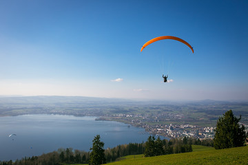 Paraglider over the Zug city, Zugersee and Swiss Alps during a s